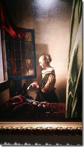 窓辺で手紙を読む女